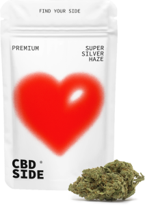 Envase premium blanco de CBD SIDE con corazón rojo para Super Silver Haze 2g, junto a una flor compacta y resinosa.